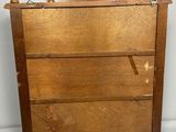 an old wooden chest of drawers with a bird on top of it