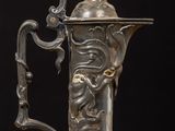 an antique silver plated coffee pot with a lion head on the handle