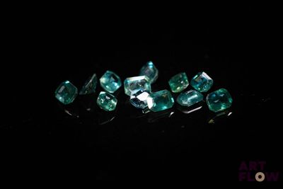 un gros plan sur un bouquet de diamants verts posés sur une surface noire