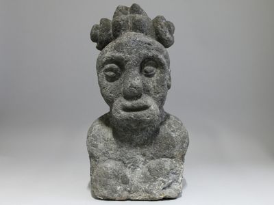 a close up of a stone statue of a man with a crown on his head