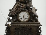 une horloge en bronze sur laquelle figurent une femme et un chien