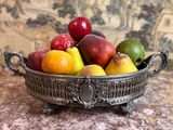 un bol de fruits posé sur une table, avec un canapé en arrière-plan