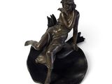 statue en bronze représentant une femme assise sur une feuille, tenant un oiseau