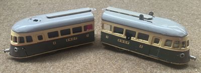 two toy trains sitting side by side on the floor