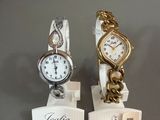 deux montres exposées sur une table, accompagnées d'une étiquette de prix