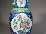 a blue and white vase with flowers and birds on it