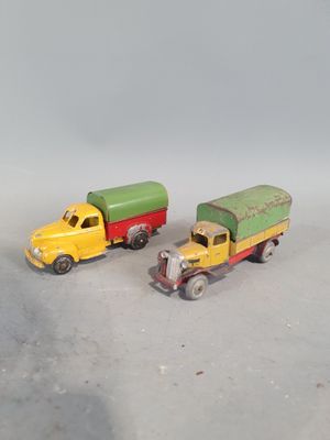 two toy trucks sitting next to each other on a table