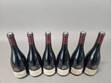 six bottles of wine are lined up in a row