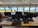 un bureau sur lequel sont posés plusieurs écrans d'ordinateur