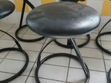 four stools that are sitting on a tiled floor