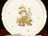 une assiette avec un couteau et une assiette sur laquelle est représenté un bateau