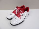 pair of red and white nike shoes on a white surface