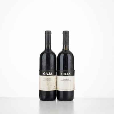 two bottles of red wine sitting on top of a table