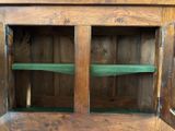 a wooden cabinet with a green shelf in it