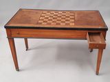 une vieille table d'échecs en bois sur laquelle est posé un damier