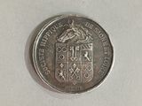 a close up of a silver coin on a white surface