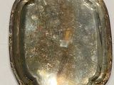 un plateau en argent posé sur une table blanche, sur fond blanc