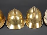 four different types of helmets are lined up on a black surface