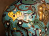 a blue vase with a gold and black design on it