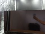 un homme debout devant un téléviseur à écran plat