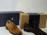 three pairs of men ' s shoes sitting on a table next to a box