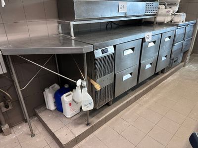 une cuisine avec de nombreux plans de travail en inox