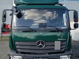 a green truck parked in front of a building
