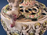 a vase that has a statue on top of it