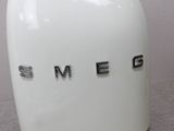 a white toaster with the word smeg written on it