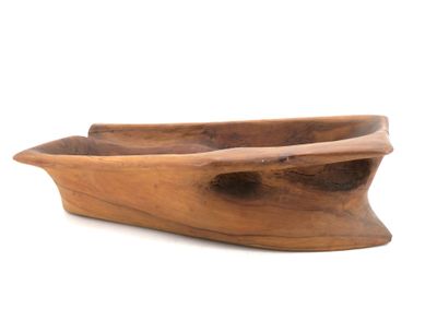 une image représentant un bol en forme de bateau en bois posé sur une surface blanche