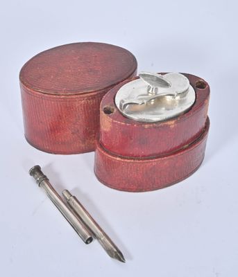a small wooden box with a metal lid and a pen