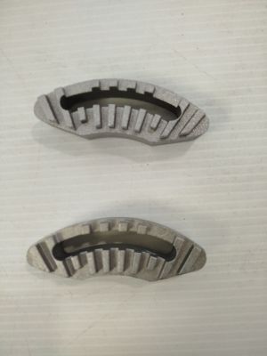 On voit deux morceaux de métal posés sur une surface blanche