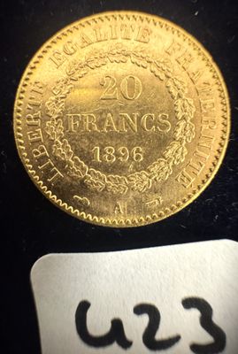 un gros plan d'une pièce d'or posée sur une surface noire, avec une étiquette de prix