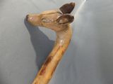 a wooden walking stick with a deer head on top of it