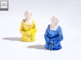 deux figurines représentant une femme et un homme assis l'un à côté de l'autre