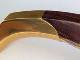 a wooden handle with a brass plate on it