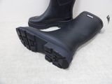 a pair of black rain boots that are on the ground