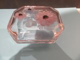 un vase en verre contenant des fleurs roses, posé sur une table