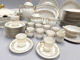a lot of white and gold plates and cups and saucers