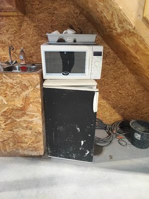 a microwave sitting on top of a refrigerator in a room