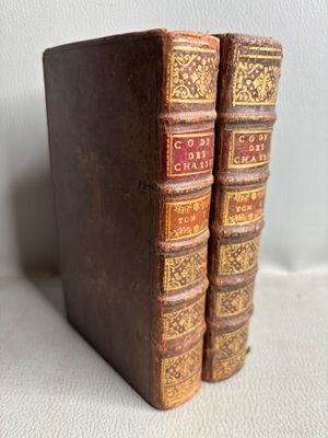 two old books sitting on top of each other on a table