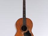an old wooden guitar hanging from the ceiling in a room