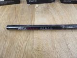 a close up of a pen sitting on a table next to boxes of makeup