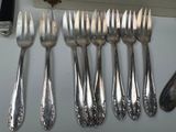 a lot of forks and spoons that are on the table