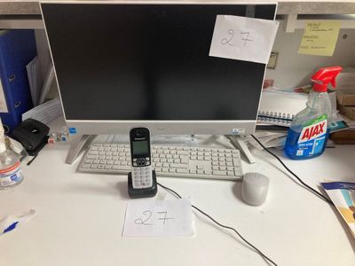 a cell phone sitting on top of a desk next to a computer monitor