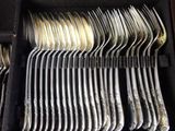 a lot of spoons and forks in a case