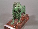 statue of a lion on a marble base on a gray background