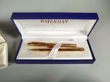 a box with two pens in it next to a box with a ring
