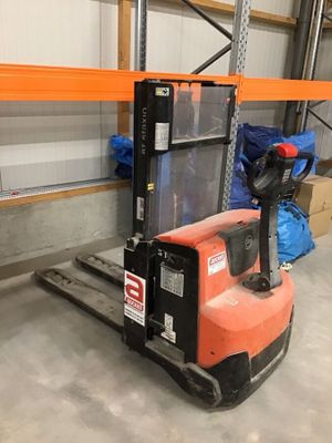 un chariot élévateur dans un entrepôt avec des boîtes sur le sol