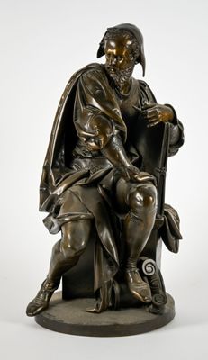statue en bronze représentant un homme assis sur une chaise avec un chien